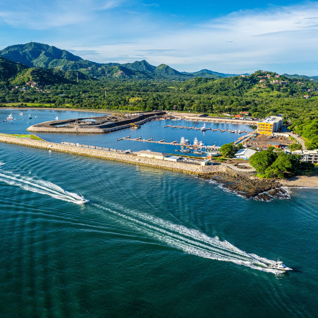 An aerial view of a marina with boats and mountains in the background.